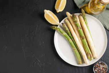 Siyah masaya baharat serilmiş yeşil ve beyaz kuşkonmaz. Metin için boşluk