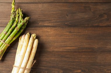 Ahşap masada yeşil ve beyaz kuşkonmaz, üst manzara. Metin için boşluk