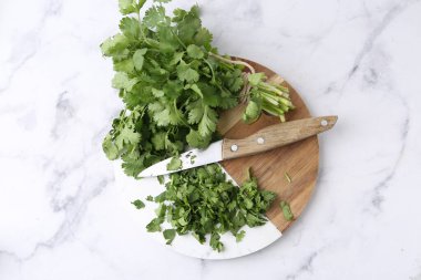 Taze yeşil kişniş ve bıçak beyaz mermer masa, üst manzara