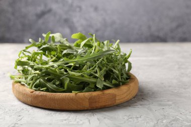 Taze yeşil roka yaprakları gri masada, yakın plan.