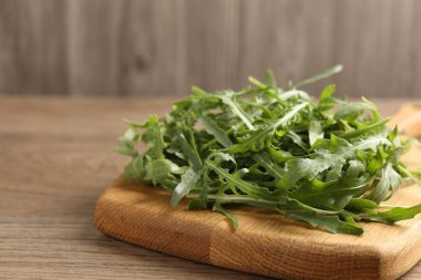 Taze yeşil roka yaprakları ahşap masada, yakın plan. Metin için boşluk