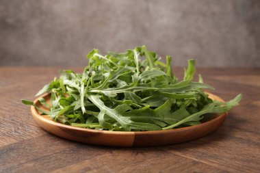 Taze yeşil roka yaprakları ahşap masada, yakın plan.