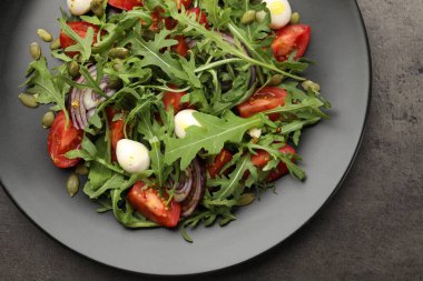 Lezzetli salata roka, mozzarella ve gri masada sebzeler.