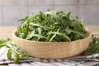 Taze yeşil roka yaprakları açık ahşap masada, yakın plan.