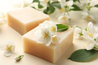 Bej arka planda sabun ve yasemin çiçekleri, yakın plan.