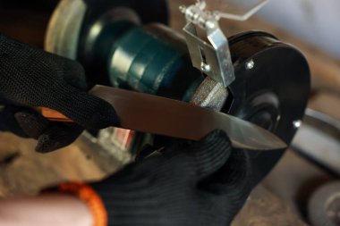 Bıçak keskinleştiren adam içeride, yakın plan.