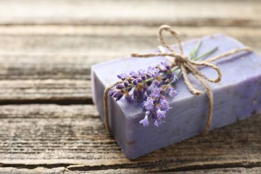 Aromatik sabun barı ve lavanta çiçekleri ahşap masada, yakın plan. Metin için boşluk