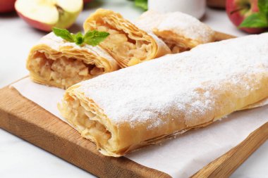 Beyaz masada pudra şekeri ve nane şekerli lezzetli elmalı turtalar, yakın plan.