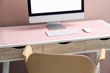 Beyaz masa üzerinde bilgisayar ve pembe fare reklamı olan şık bir iş yeri. Metin için boşluk