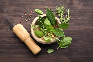 Farklı taze otlu havan, biber ve ahşap masa üzerinde tokmak, düz yatıyordu