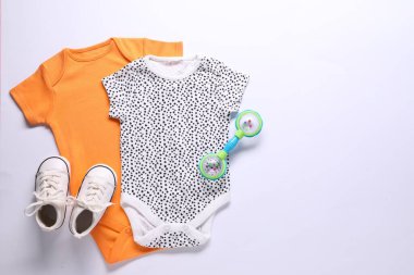 Beyaz arka planda bebek kıyafetleri ve aksesuarlar, düz yatış. Metin için boşluk