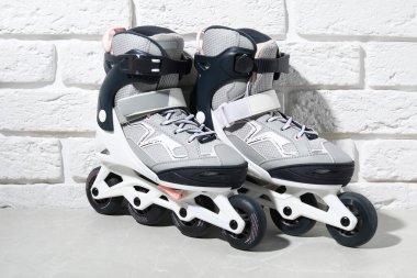 Beyaz tuğla duvarın yanındaki gri mermer masada patenler.