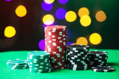 Kumarhane fişleri yeşil masada bulanık ışıklara karşı, yakın plan