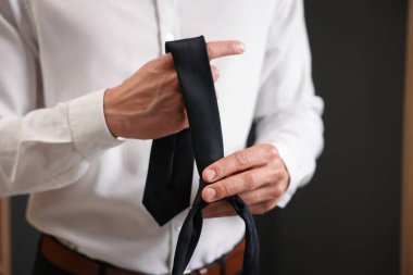 Evde şık siyah kravatlı bir adam, yakın plan.