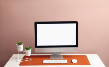 Beyaz masa üzerinde bilgisayar ve turuncu fare reklamları olan şık bir iş yeri. Metin için boşluk