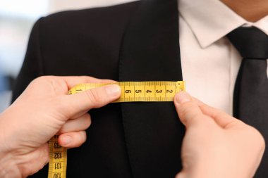 Atölyedeki adama terzi ceketi, yakın plan.