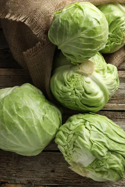 Ahşap masada taze lahanalar, düz uzanmış.