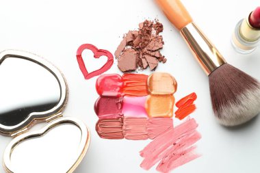 Farklı kozmetik ürünleri, beyaz arka planda ayna ve makyaj fırçası, düz konum