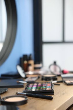 Kapalı alanda, ahşap masada farklı makyaj ürünleri var. Metin için boşluk