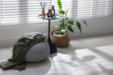 Ekoseli ve ev dekorlu şık bir pouf.