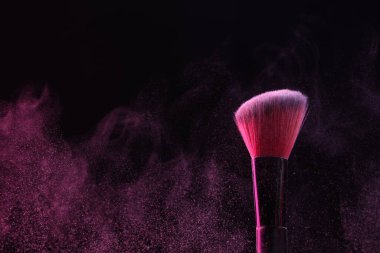 Siyah arka planda pembe göz farlı makyaj fırçası, yakın plan.