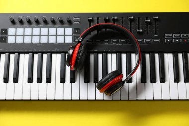Sarı arka planda kulaklıklı MIDI klavyesi, üst görünüm