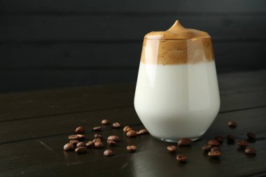 Bardakta lezzetli dalgona kahvesi ve ahşap masada fasulye, yakın plan. Metin için boşluk