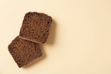 Bej arka planda taze çavdar ekmeği parçaları, üst manzara. Metin için boşluk