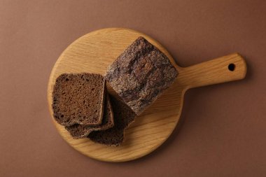 Kahverengi arka planda taze çavdar ekmeği parçaları.