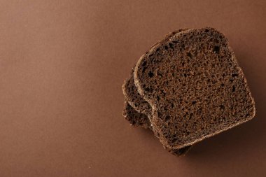 Kahverengi arka planda taze çavdar ekmeği parçaları, üst manzara. Metin için boşluk