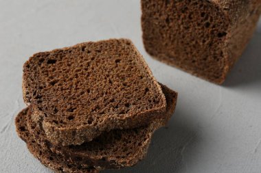 Açık gri desenli masada taze çavdar ekmeği parçaları, yakın plan.