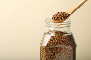 Bej arka planda kaşıkla hazır kahve içmek, yakın plan. Metin için boşluk