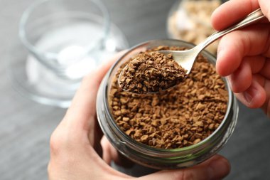 Masada kavanozdan hazır kahve alan kadın, yakın plan.