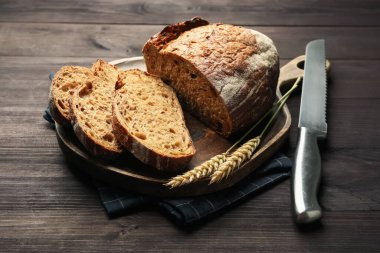 Taze ekmek parçaları, bıçak ve çiviler ahşap masada, yakın plan.