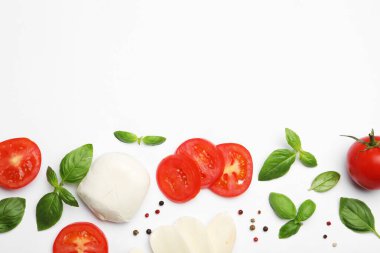 Lezzetli mozzarella peyniri, domates, fesleğen ve beyaz arka planda karabiber. Metin için boşluk