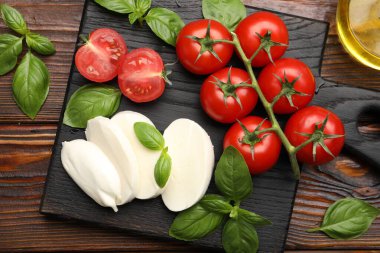 Lezzetli mozzarella peyniri, domates ve fesleğen, ahşap masa, düz uzanma