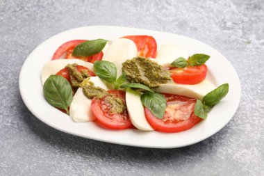 Mozarella, domates, fesleğen ve pesto soslu lezzetli salata Caprese, yakın plan.