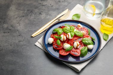 Caprese salatası, gri masadaki balzamik sirkeyle servis edilir. Yakın plan. Metin için boşluk