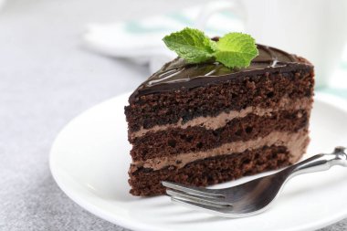 Gri masadaki çatal ve naneli çikolatalı kek, yakın plan.