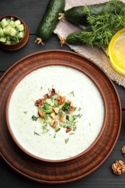 Lezzetli salatalık çorbası, dereotu, ceviz ve malzeme siyah ahşap masa, düz yatıyordu.