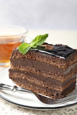 Nane, çatal ve çayla servis edilen çikolatalı kek.