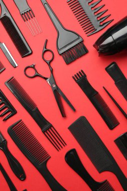 Kırmızı arka planda farklı kuaför aletleri, düz yatıyordu
