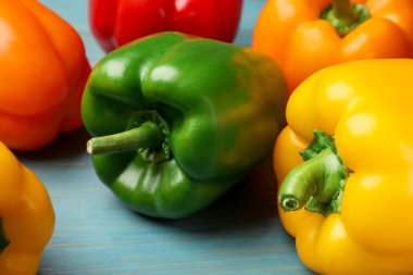 Mavi ahşap masada taze dolmalık biberler, yakın plan.