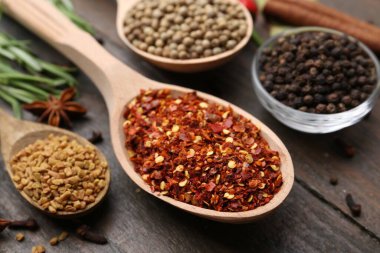 Ahşap masada farklı aromatik baharatlar, yakın plan.