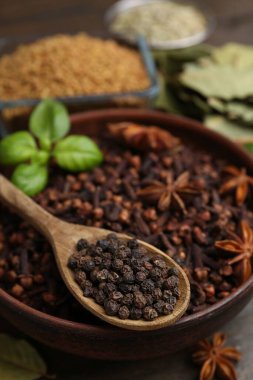 Ahşap masada farklı aromatik baharatlar, yakın plan.