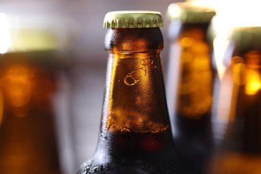 Bulanık gri arka planda bir şişe lezzetli bira, makro manzara.