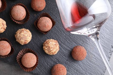 Lezzetli yer mantarı bonbonları ve gri desenli masada arta kalan kırmızı şarap.