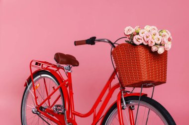 Pembe arka planda bir sepet güzel çiçekli bisiklet.