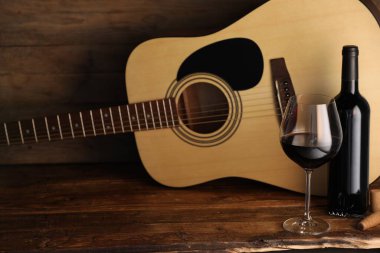 Akustik gitar, şişe ve bir bardak kırmızı şarap.