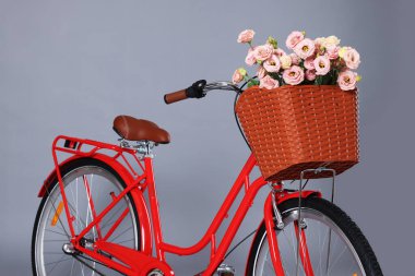 Gri arka planda bir sepet güzel çiçekli bisiklet.